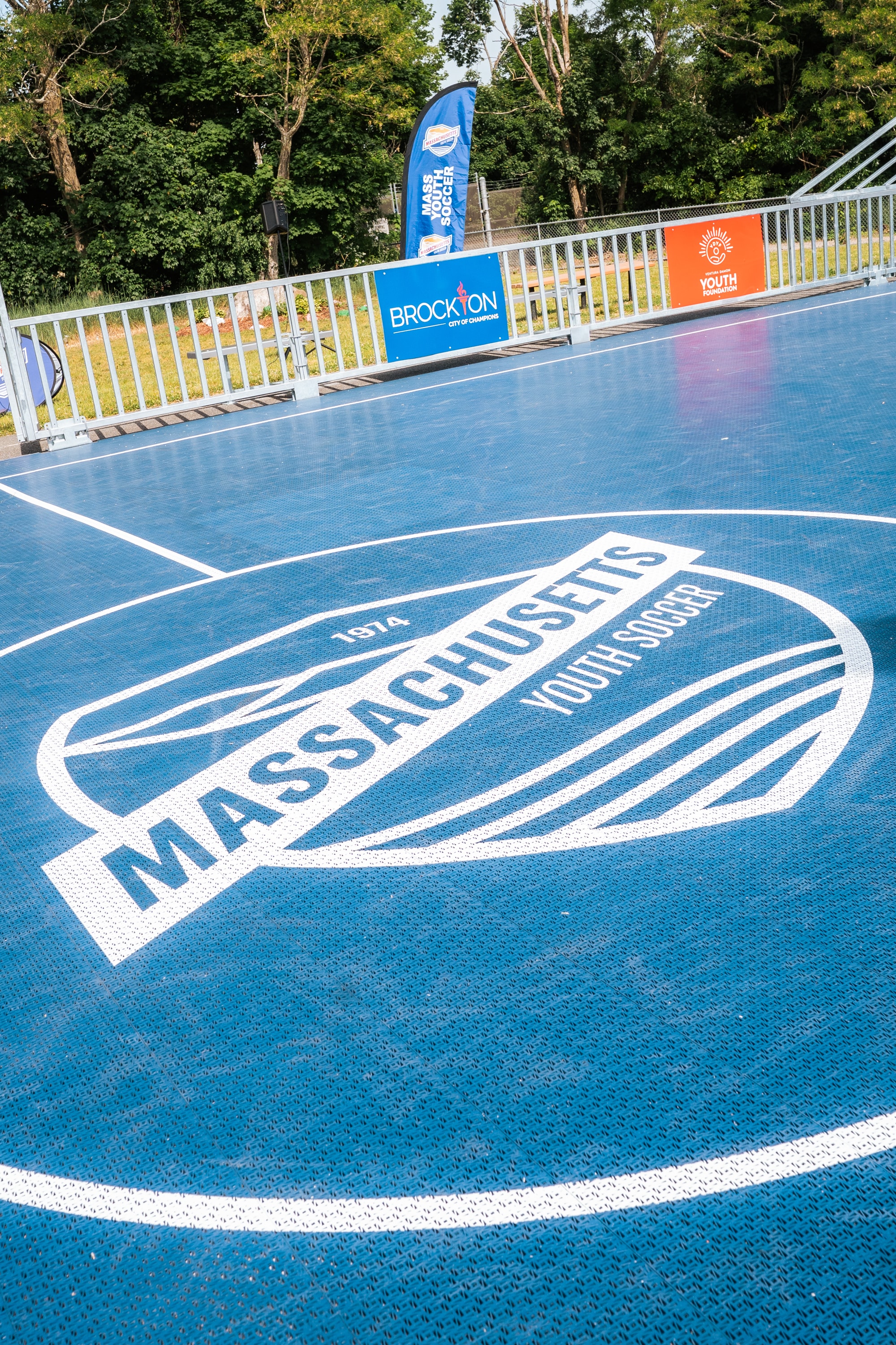 Young player with Massachusetts Youth Soccer banner at Mulberry Park